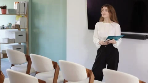 Qualified female coach with papers in her hands makes a presentation for Stock Footage 346132155