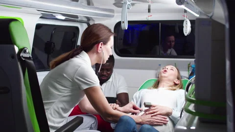 Qualified paramedic helping to calm down woman screaming and pushing during Stock Footage 225474362