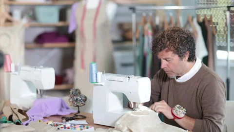 Qualified tailor sews custom-made clothes in the workshop Stock Footage 316578577
