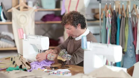 Qualified tailor sews custom-made clothes in the workshop Stock Footage 325773008