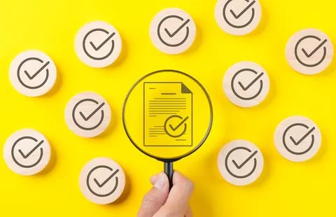 Quality assurance document control concept. Magnifying glass focus Foto stock