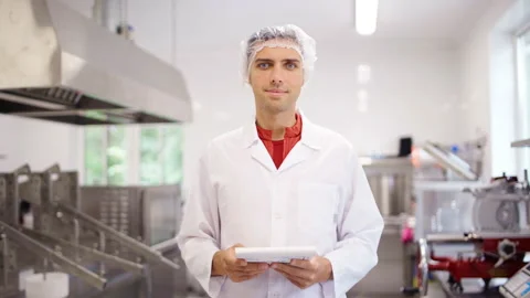 Quality control expert in white coat smiling at food factory Stock Footage 161194876