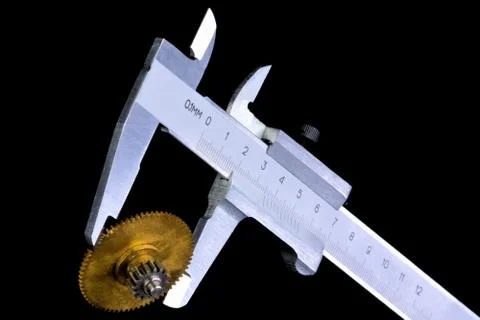 Quality control measuring the size of a caliper-toothed wheel. Stock Photos