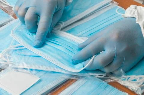 Quality control operator checks the seams of a surgical mask Stock Photos