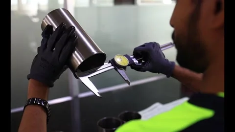 Quality control technician using analog dial vernier caliper to measure Stock Footage 336797355