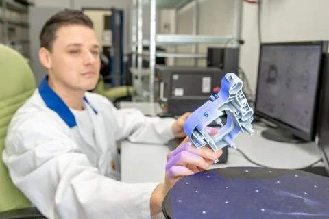 Quality engineer examines a sample scanned with a laser on a 3d scan in a Stock Photos