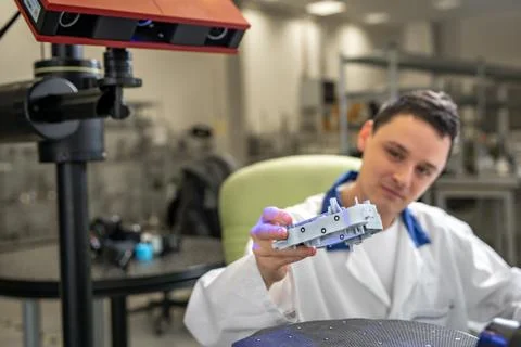 Quality engineer examines a sample scanned with a laser on a 3d scan in a Stock Photos