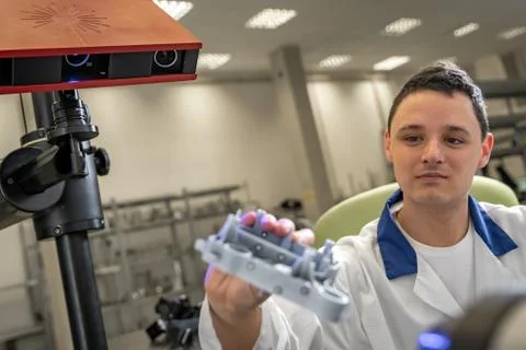 Quality engineer examines a sample scanned with a laser on a 3d scan in a Stock Photos