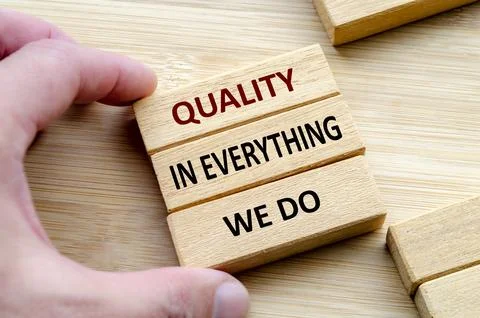 QUALITY IN EVERYTHING WE DO text on cubes held by hands, Commitment to qual.. Stock Photos