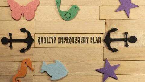 Quality improvement plan written on wooden surface. Education and child devel Stock Photos