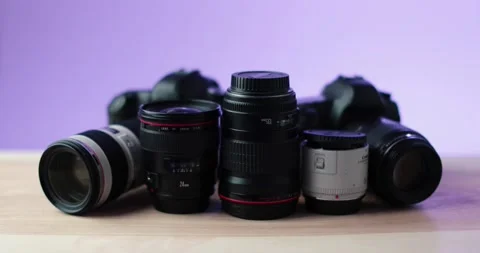 Quality name brand camera along equipment in front of purple background studio Stock Footage 237546266