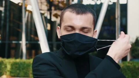 Quarantine is over concept. Man taking off mask against the background of urban Video stock 143356397
