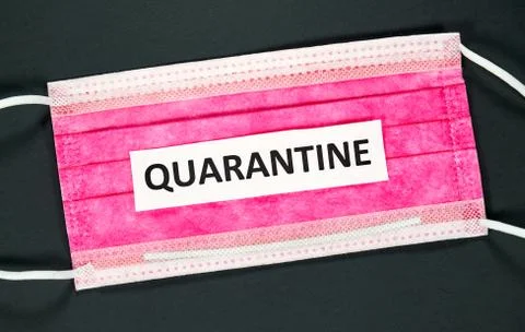 Quarantine word on a red mask on black background. Photos