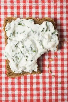 Quark &amp; ramsons on wholemeal bread, a bite taken (overhead) Stock Photos