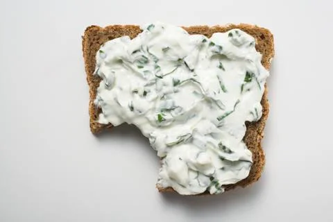 Quark &amp; ramsons on wholemeal bread, a bite taken (overhead) Stock Photos