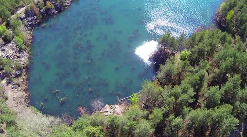 The quarry filled with water. Sun reflected in water. Aerial view. Stock-Footage 49825738