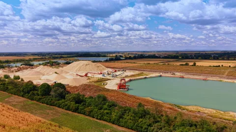 Quarry lake and sand processing plant beneath clouds. A red floating structure Stock Footage 346483203