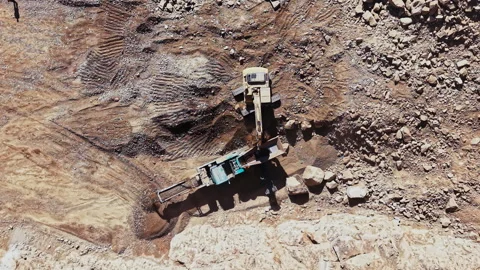 Quarry machine loads broken rock at an open excavation site during daytime Stock Footage 347895280