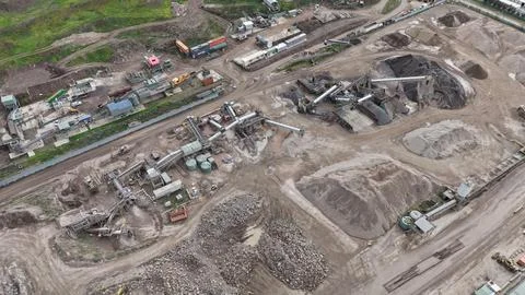 Quarry processing plant with heavy machinery and gravel piles Photos