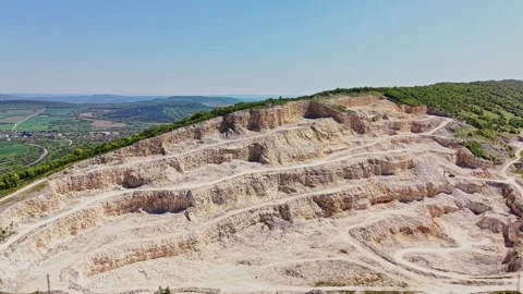 Quarry site located in rural area with layered rock formations and path Stock Footage 338276203