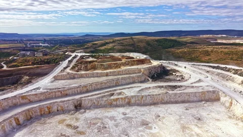 Quarry site showing layers of earth and machinery with landscape in background Stock Footage 345455435