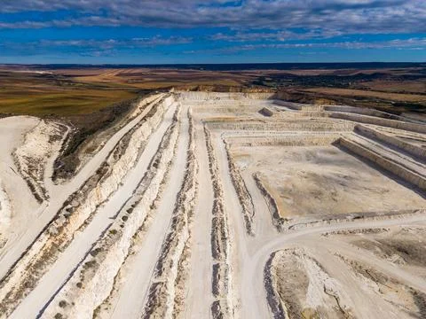 Quarry site showing multiple levels and pathways in a landscape during dayt.. Stock Photos