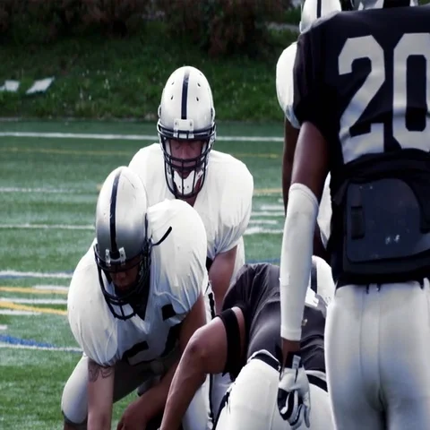 A Quarterback drops back and gets sacked by a defender. Stock Footage 69378161