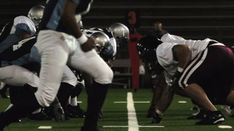 Quarterback snaps the ball and drops back and gets sacked by a defender Stock Footage 33870995