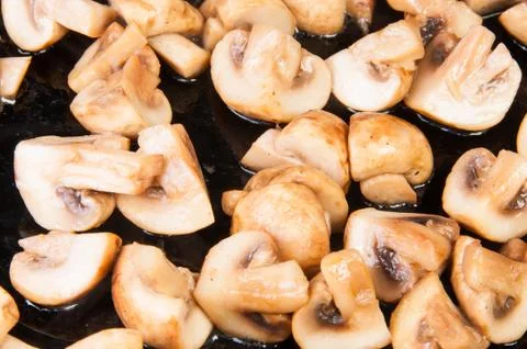 Quartered roasted champignons Stock Photos