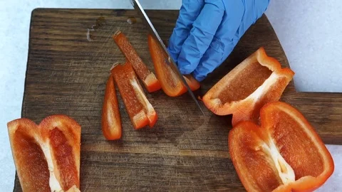 The quartets of red pepper is being sliced for smaller pieces by chief. Stock Footage 82358594
