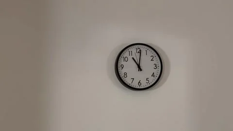 Quartz clock hangs on a white wall Stock Footage 337665844