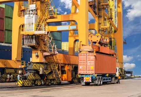 Quay crane loading container from container ship to container truck for trans Stock Photos