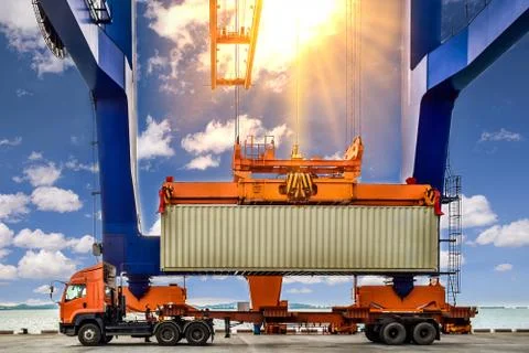 Quay crane loading container on to truck Stock Photos