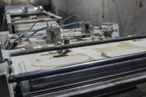 Quboos (Arabic Bread) making process the dough cut in to round shape passing thr Stock Photos
