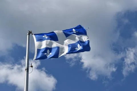The Quebec flag under a blue sky Stock Photos