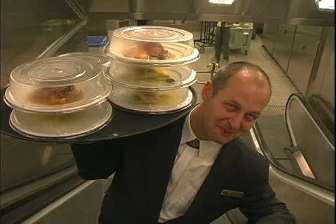 QUEEN MARY 2, 2004, Ocean liner, galley steward pickups meal, carry up escalator Stock Footage 20466171