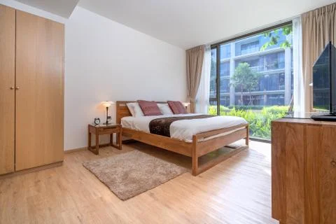 Queen size bed with bed runner and reading lamp in villa, house and apartment Stock Photos