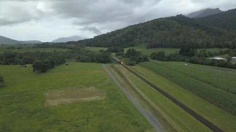 Queensland Rail Train passes through green fields near Cairns Stock Footage 128937277