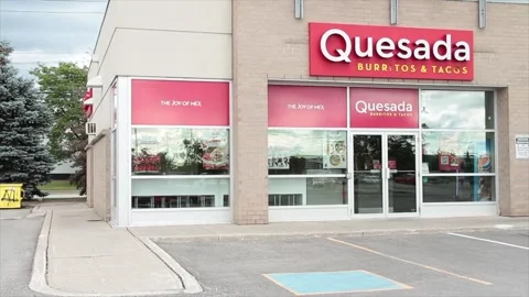 Quesada burritos and tacos front entrance store restaurant with parking spaces Stock Footage 250284092
