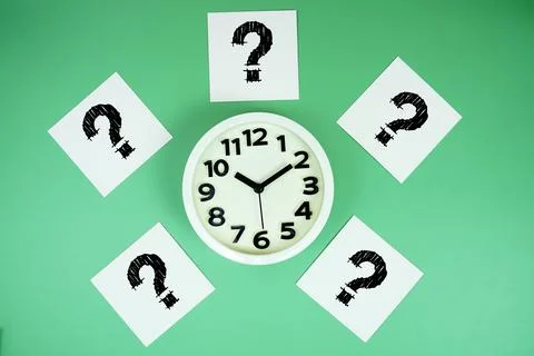 Question Mark with alarm clock on green background Stock Photos