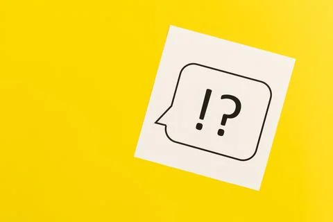 Question mark and exclamation mark on yellow background, flat lay. Stock Photos