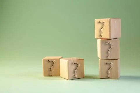 Question mark and question mark on wooden blocks on green background with c.. Stock Photos