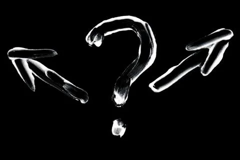 Question mark with arrows hand painted on black background Stock Photos