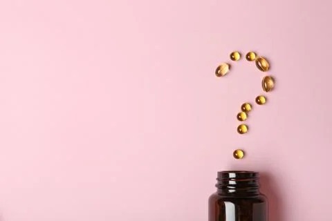 Question mark of cod liver oil capsules and jar on color background, flat lay Stock Photos