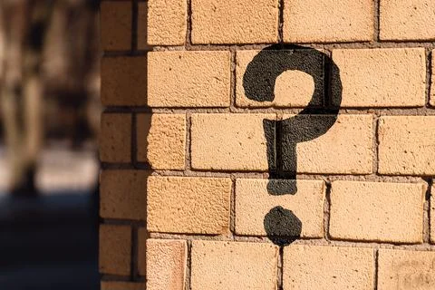 Question mark concept or FAQ. The sign is painted on a brick wall Stock Photos
