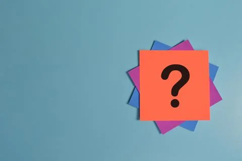 Question mark drawn on paper note isolated on blue background Stock Photos