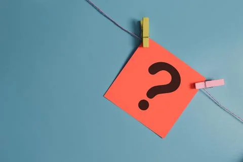 Question mark drawn on paper note isolated on blue background Stock Photos