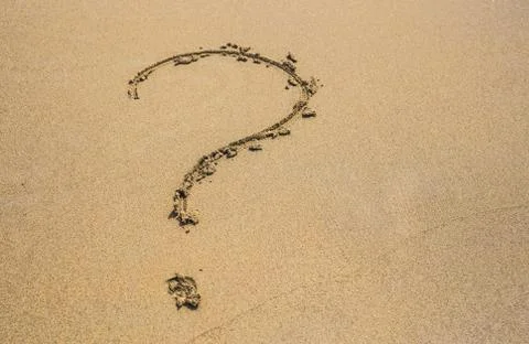 Question mark drawn on the sand of a beach in summer Stock Photos