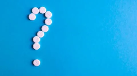Question mark made of many white pills on a blue background. Healthcare con.. 스톡 사진