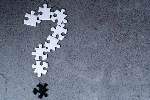 Question mark made of white puzzle pieces with one black piece Stock Photos